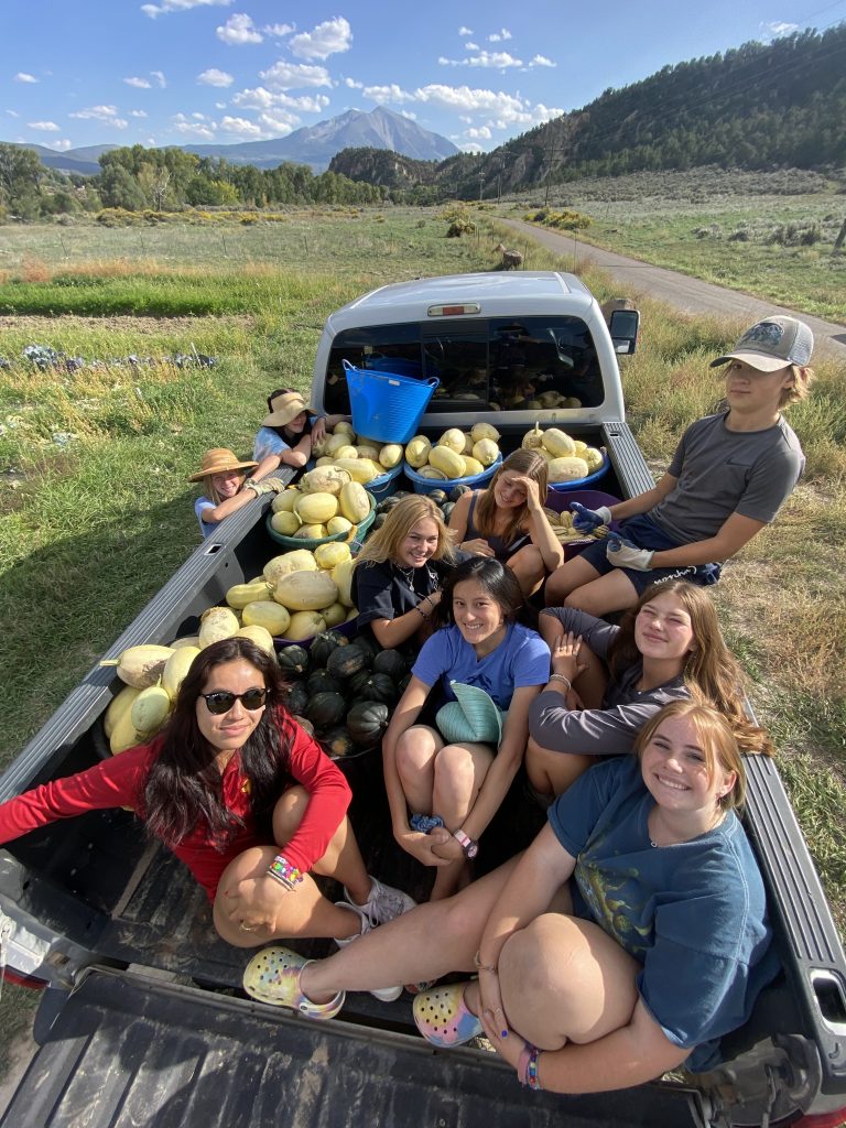 Garden crew in a pick up truck with butternut squash harvest